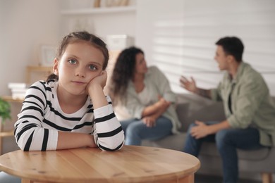 Photo of Divorce concept. Angry couple arguing at home, focus on their sad daughter