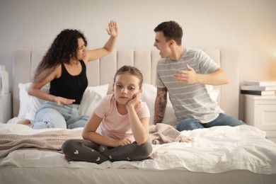 Divorce concept. Angry couple arguing in bedroom, focus on their sad daughter