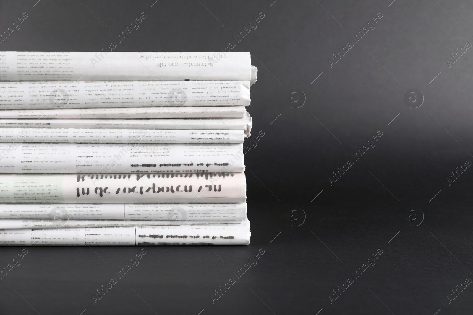 Photo of Stack of many newspapers in different languages on grey background, space for text