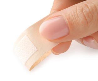 Photo of Woman putting medical adhesive bandage on white background, closeup