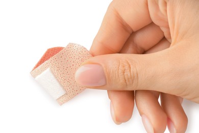 Photo of Woman putting medical adhesive bandage on white background, closeup