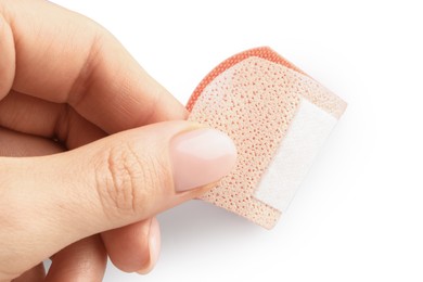 Photo of Woman putting medical adhesive bandage on white background, closeup