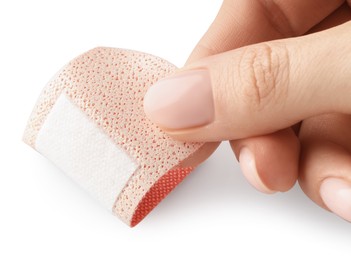 Photo of Woman putting medical adhesive bandage on white background, closeup