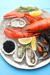 Many different sea food on light blue wooden table, top view