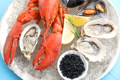 Photo of Many different sea food on light blue table, closeup