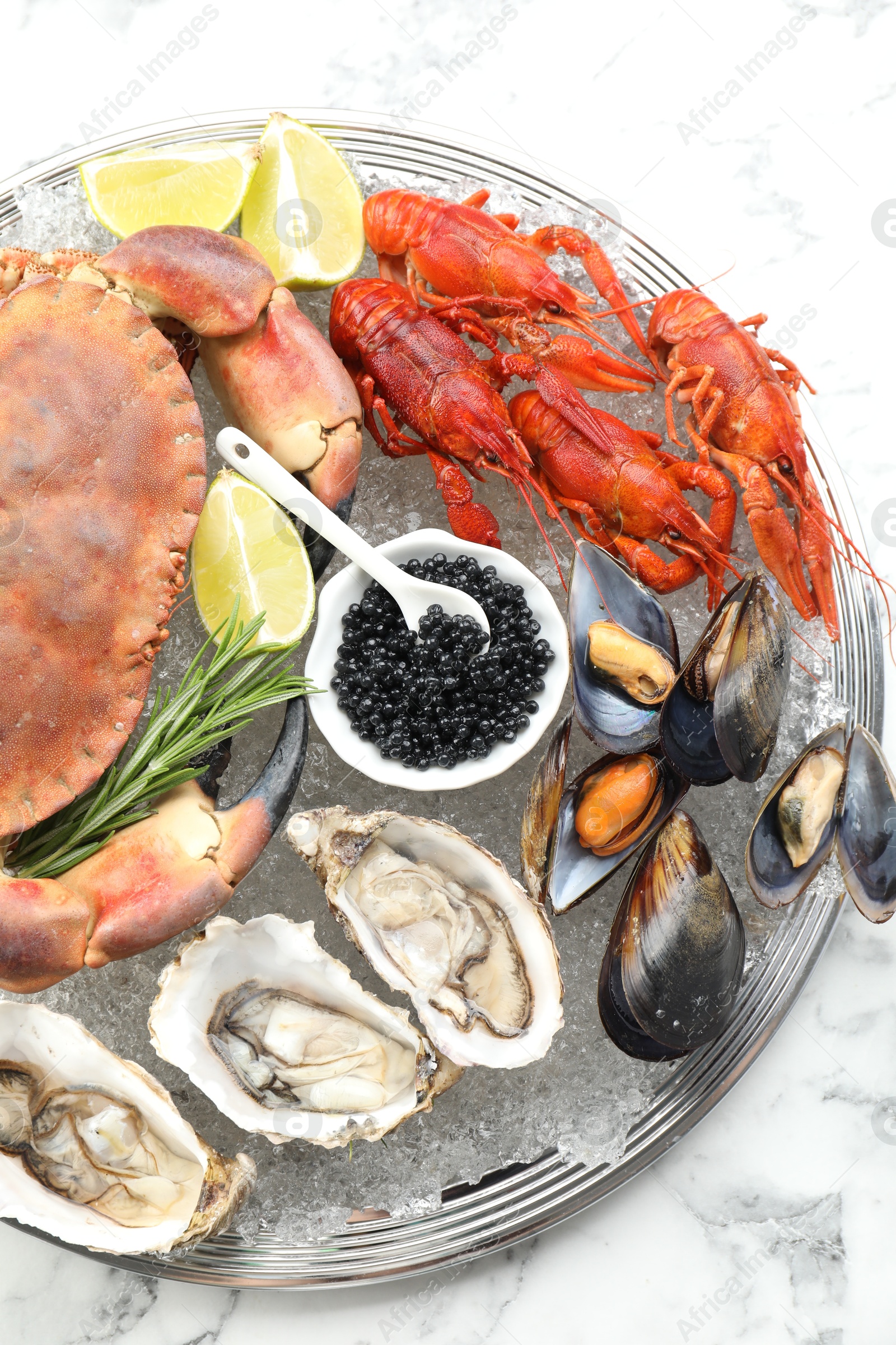 Photo of Many different sea food on white marble table, top view