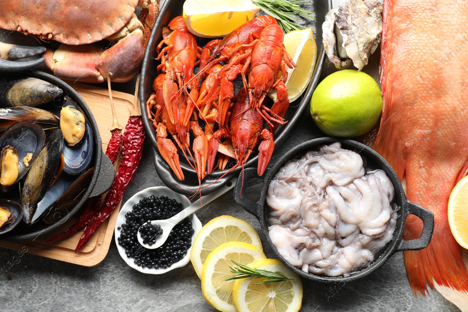 Photo of Many different sea food on grey table, top view