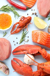 Many different sea food and spices on light blue background, flat lay