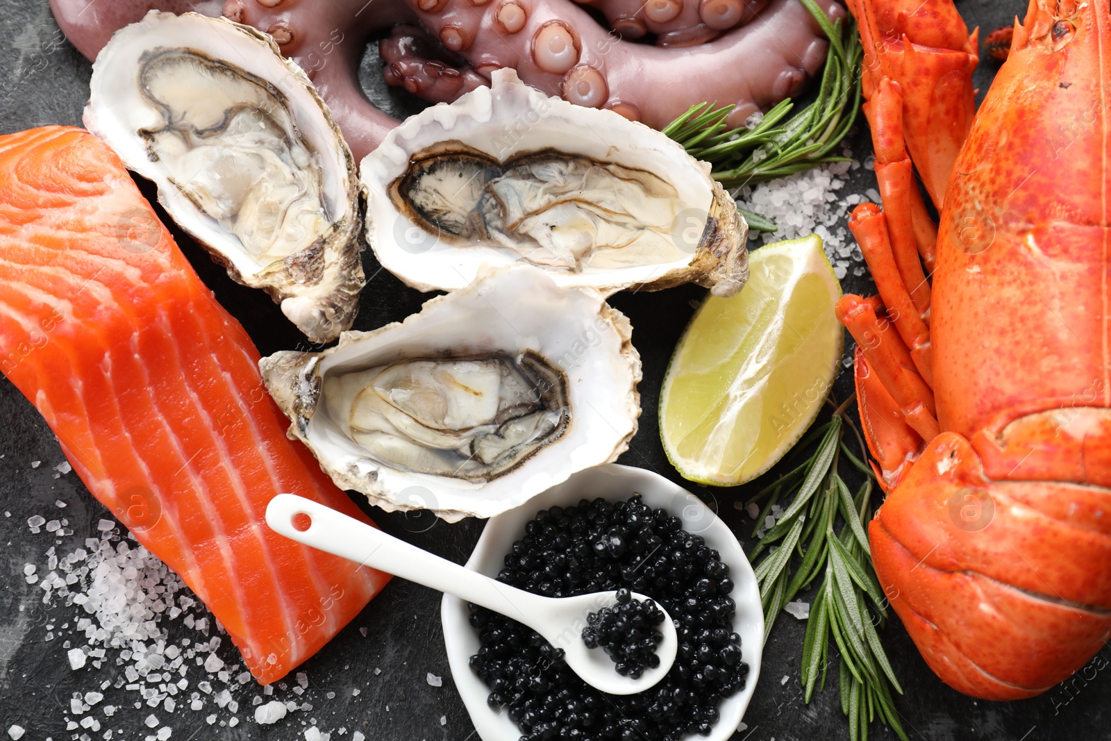 Photo of Many different sea food on dark table, top view