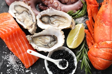 Many different sea food on dark table, top view