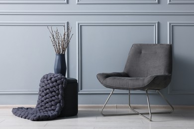 Photo of Stylish stool, chair and vase near light grey wall indoors