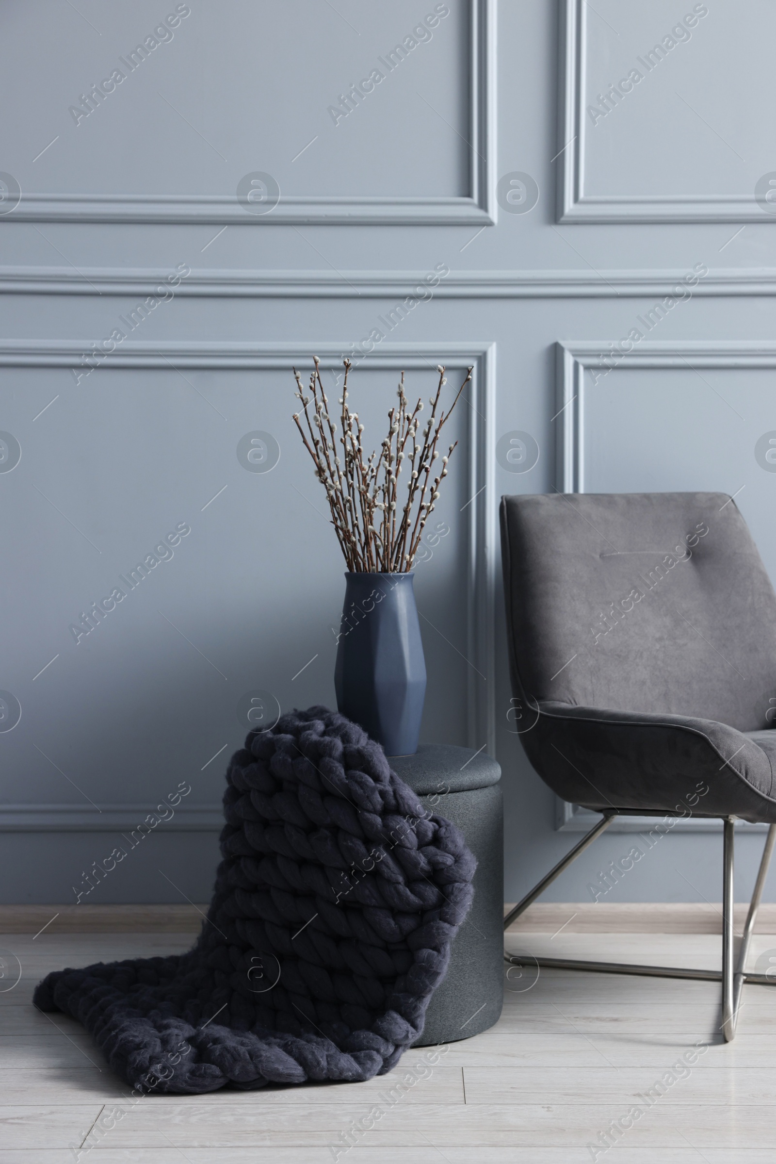 Photo of Stylish stool, chair and vase near light grey wall indoors