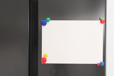 Photo of Blank note board with magnets on refrigerator in kitchen. Mockup for design