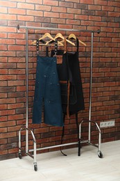 Photo of Many chef's aprons hanging on brick wall