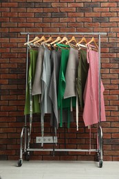 Photo of Many chef's aprons hanging on brick wall