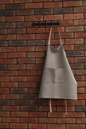 Photo of One chef's apron hanging on brick wall