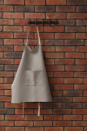 Photo of One chef's apron hanging on brick wall