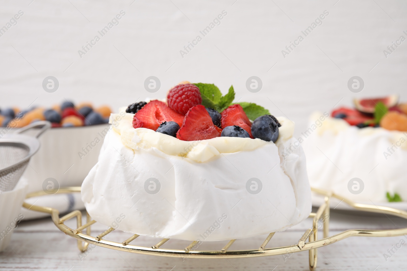 Photo of Pavlova cake (meringue dessert) with whipped cream, fresh berries and mint on table, closeup