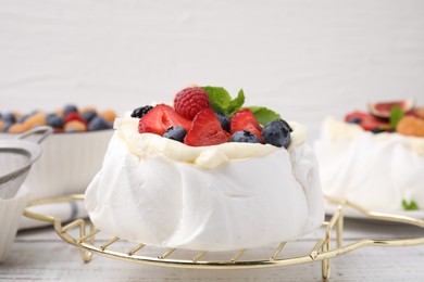 Pavlova cake (meringue dessert) with whipped cream, fresh berries and mint on table, closeup