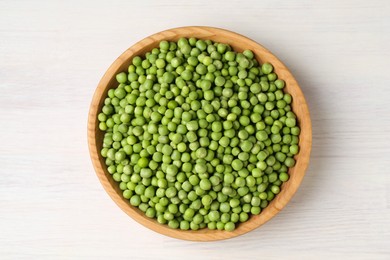 Photo of Fresh green peas in bowl on white wooden table, top view