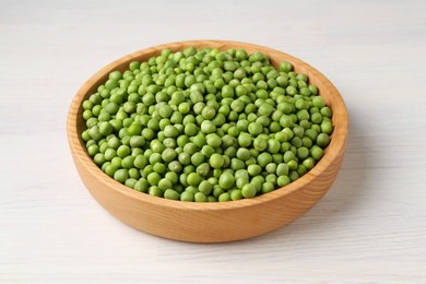 Photo of Fresh green peas in bowl on white wooden table, closeup