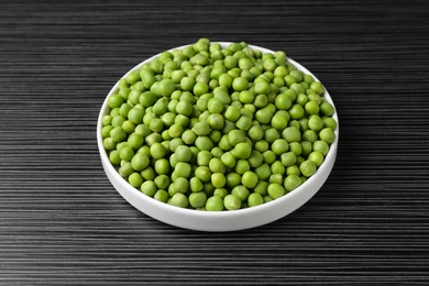 Photo of Fresh green peas on black wooden table, closeup