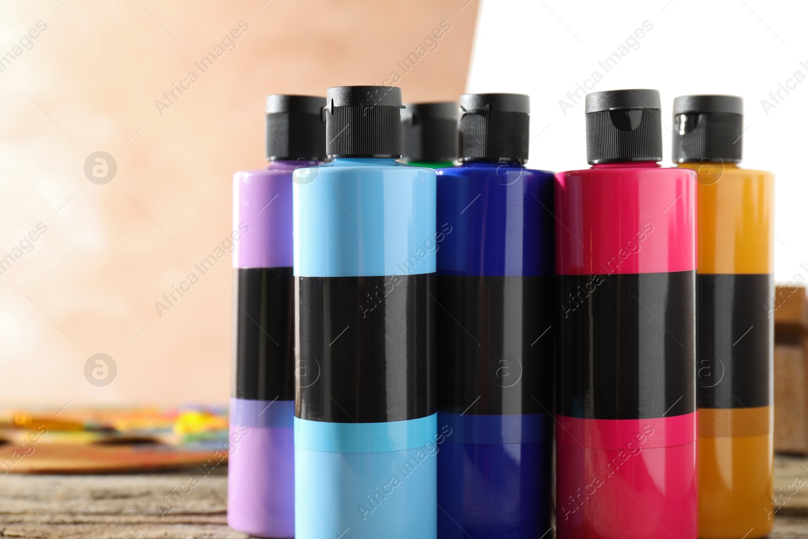 Photo of Acrylic paints of different colors in bottles on table, closeup