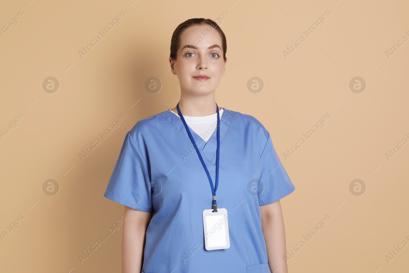 Photo of Professional nurse with badge on dark beige background