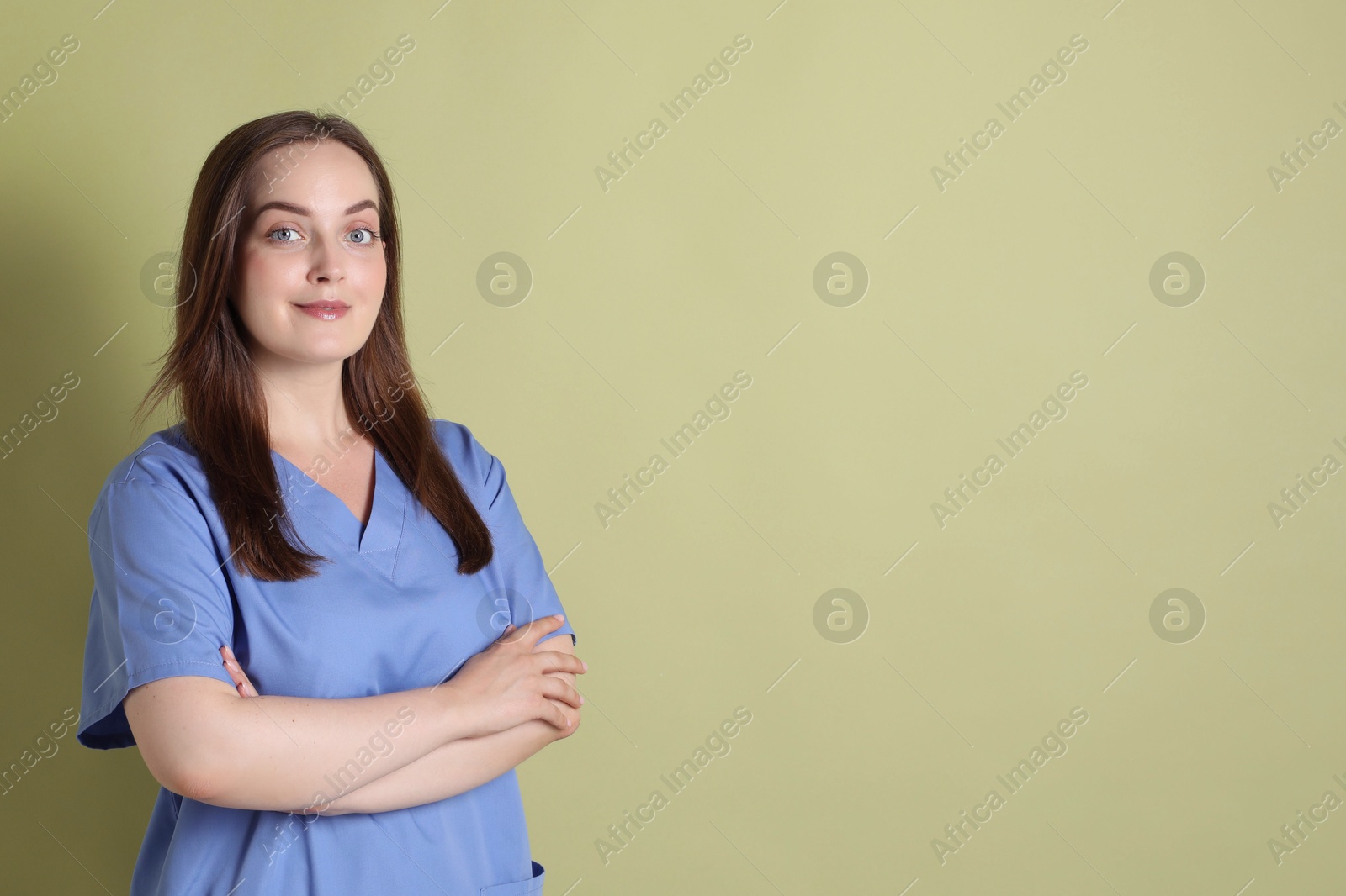 Photo of Professional nurse in uniform on pale green background. Space for text