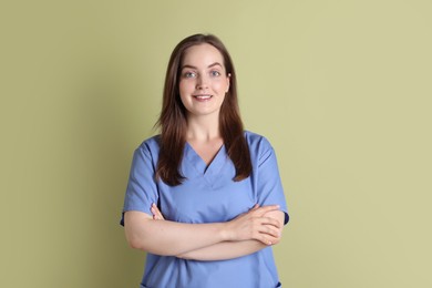 Photo of Professional nurse in uniform on pale green background