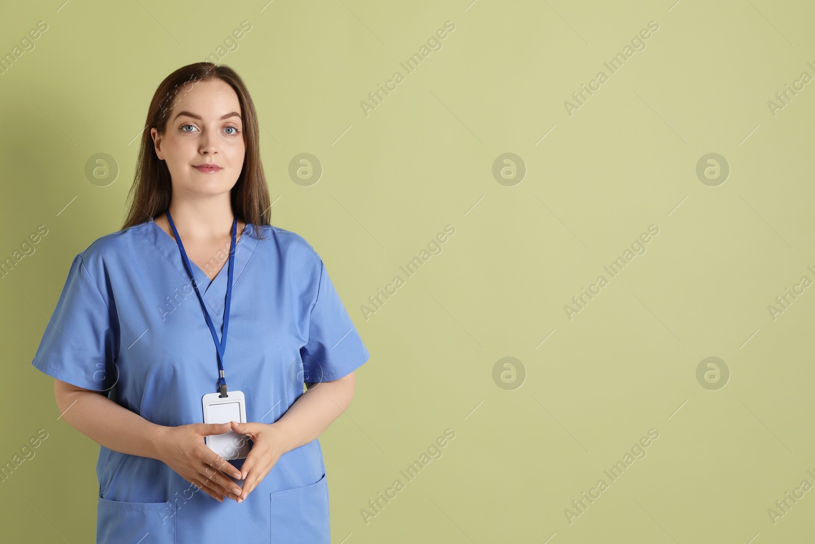 Photo of Professional nurse with badge on pale green background. Space for text