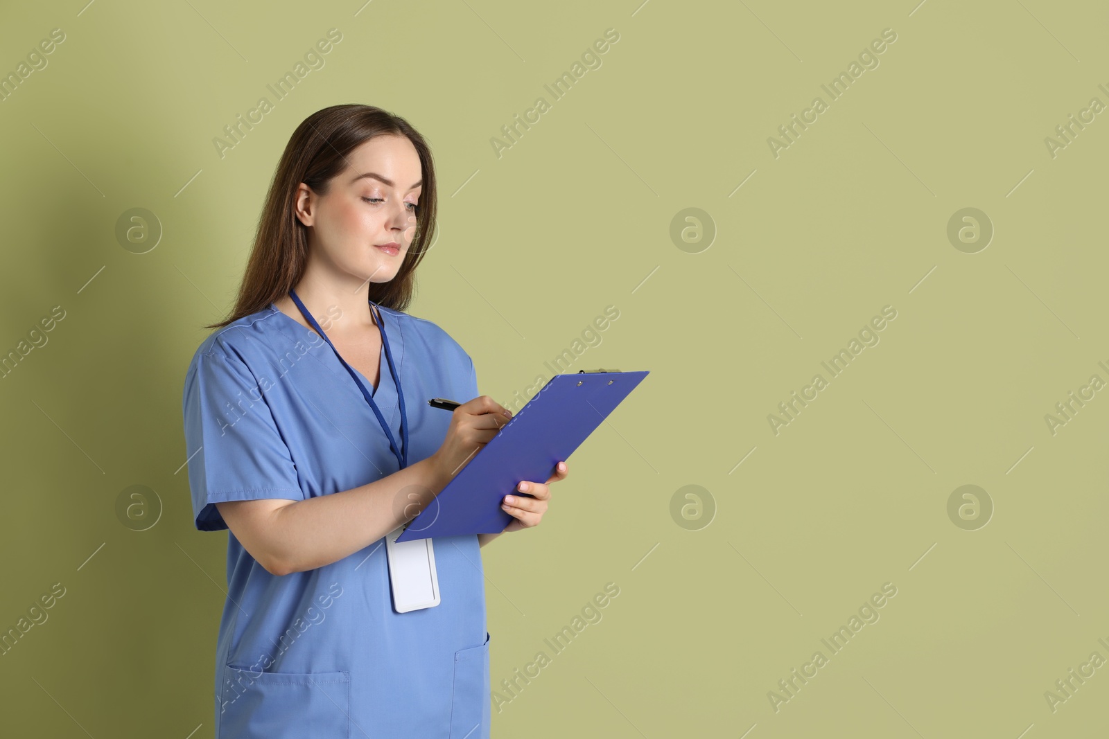 Photo of Professional nurse with clipboard on pale green background. Space for text