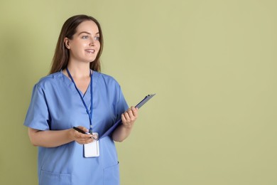 Photo of Professional nurse with clipboard on pale green background. Space for text