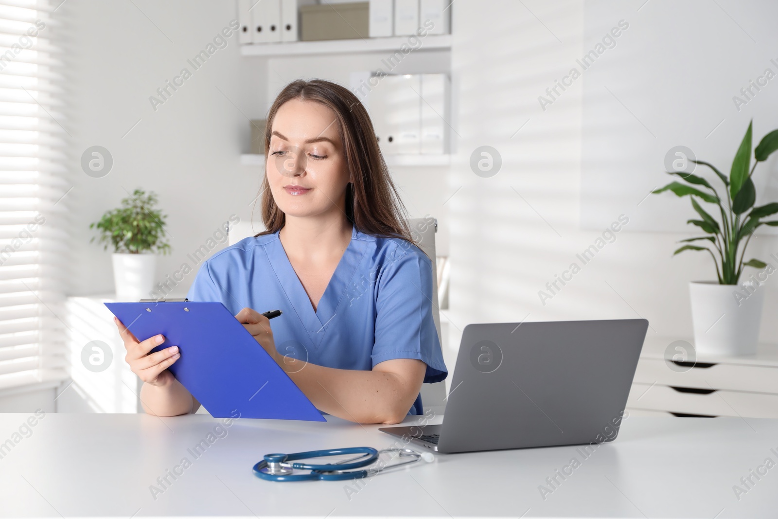 Photo of Young nurse working at desk in hospital