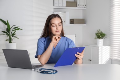 Photo of Young nurse working at desk in hospital