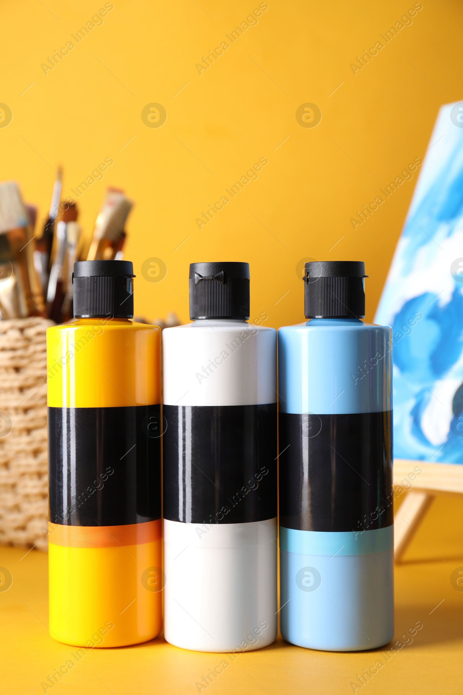 Photo of Acrylic paints of different colors on orange background