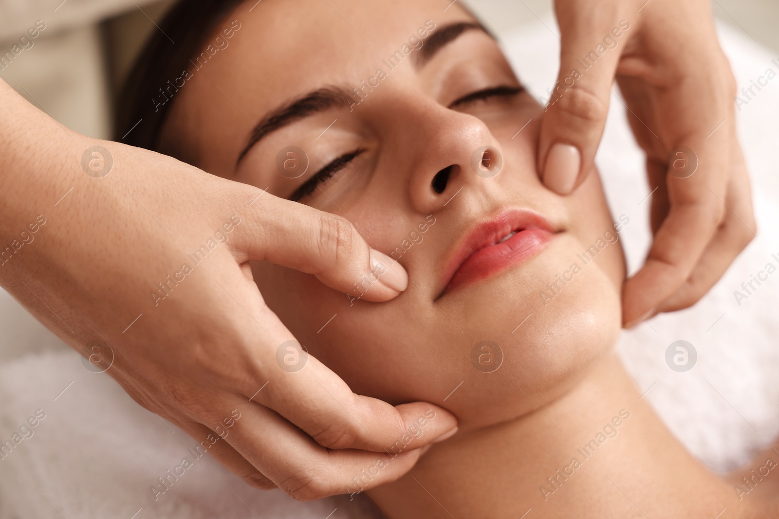 Photo of Attractive woman enjoying face massage, closeup. Beauty procedure