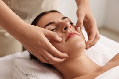 Photo of Attractive woman enjoying face massage, closeup. Beauty procedure