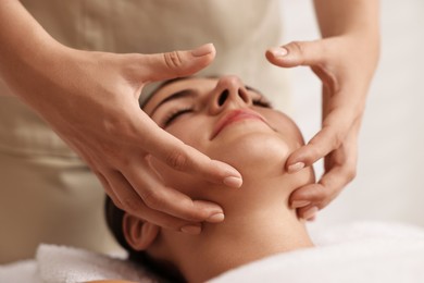 Photo of Attractive woman enjoying face massage, closeup. Beauty procedure