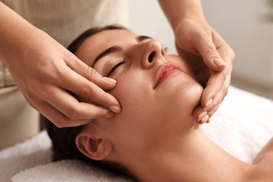 Photo of Attractive woman enjoying face massage, closeup. Beauty procedure