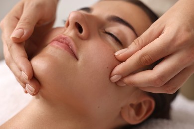 Photo of Attractive woman enjoying face massage, closeup. Beauty procedure