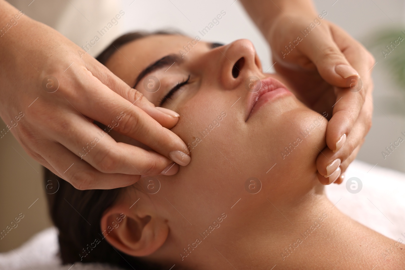 Photo of Attractive woman enjoying face massage, closeup. Beauty procedure