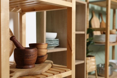 Photo of Wooden storage stands with kitchenware indoors, closeup