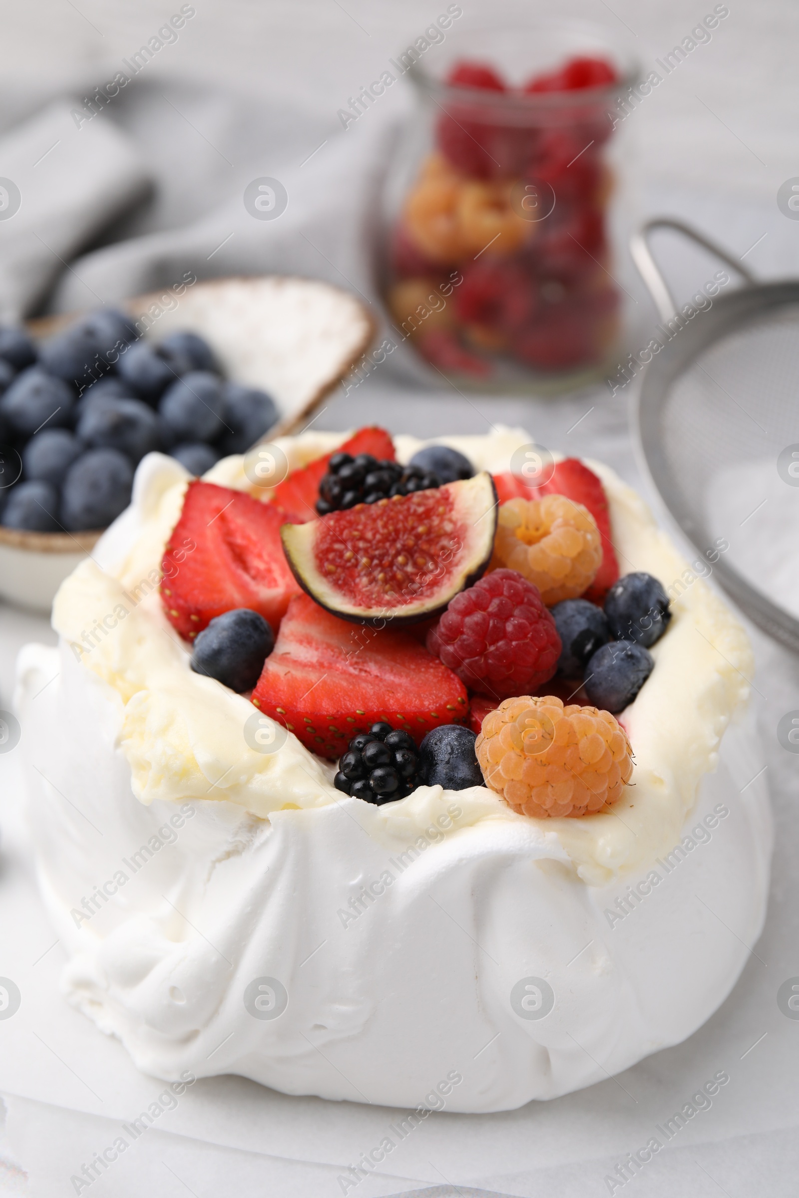 Photo of Pavlova cake (meringue dessert) with whipped cream, fresh berries and fig on table, closeup