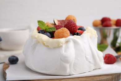 Photo of Pavlova cake (meringue dessert) with whipped cream, fresh berries and mint on table, closeup