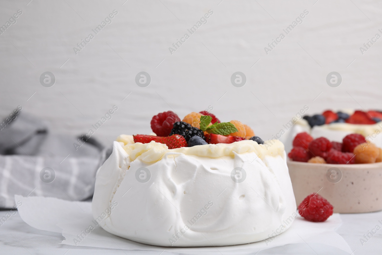 Photo of Pavlova cake (meringue dessert) with whipped cream, fresh berries and mint on table, closeup