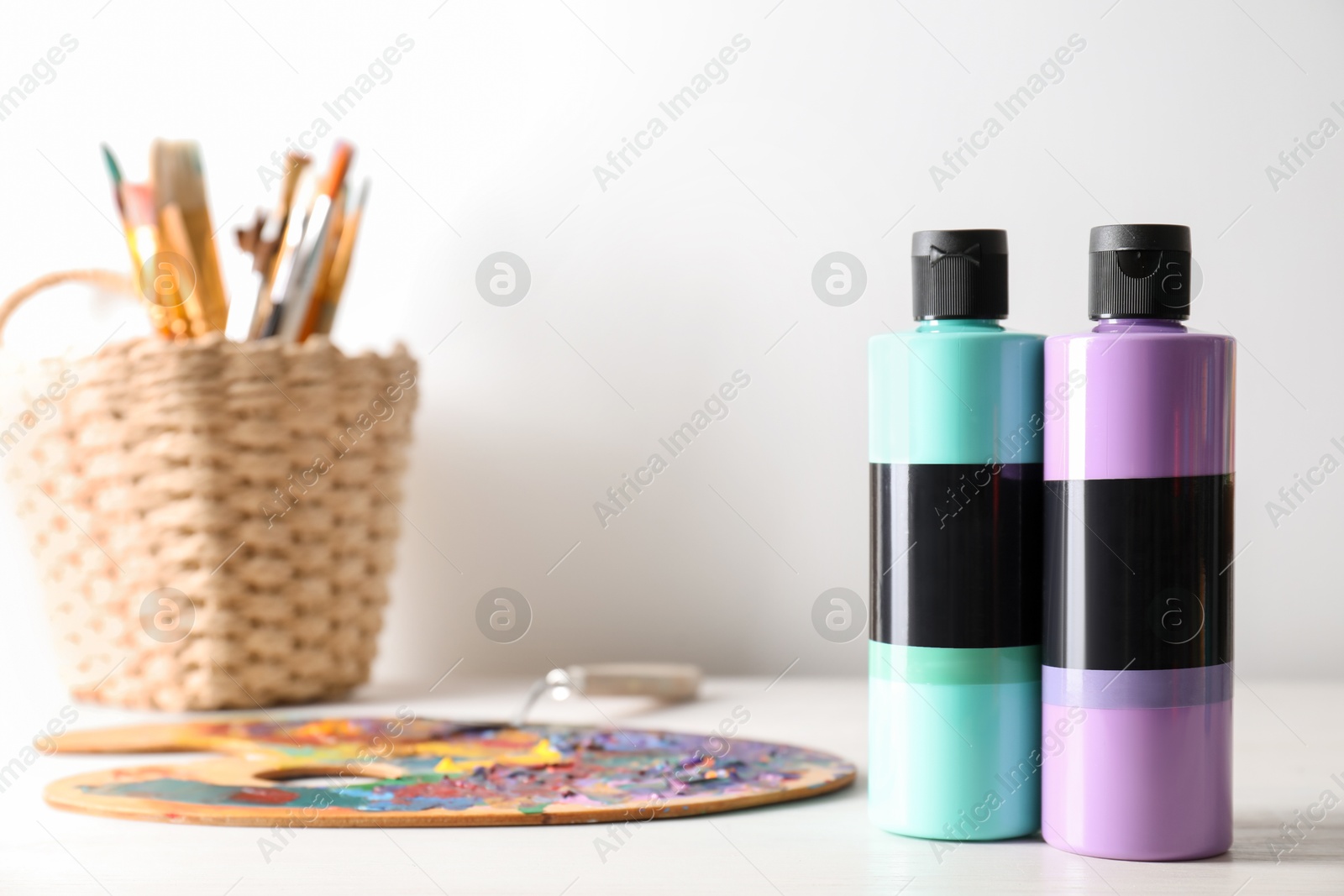 Photo of Acrylic paints of different colors, palette and brushes on wooden table