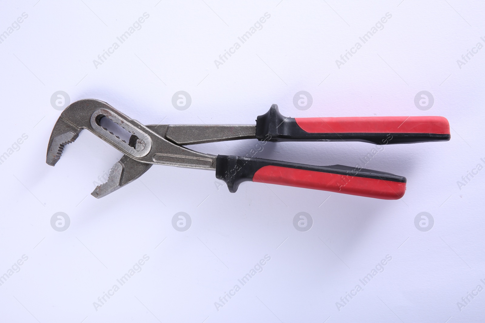 Photo of Adjustable pliers isolated on white, top view. Construction tool