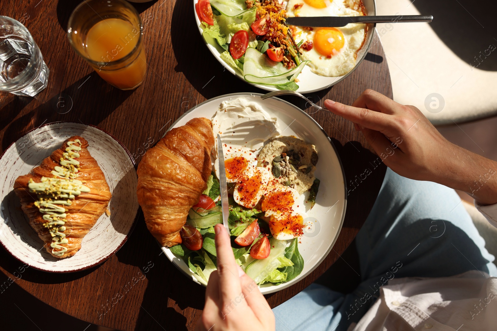 Photo of Man having tasty breakfast at wooden table in cafe, top view