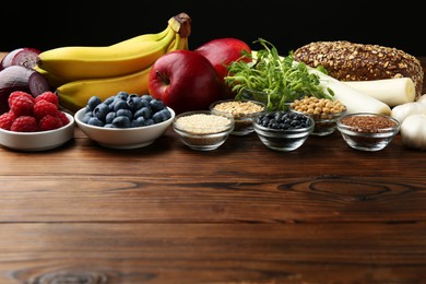 Photo of Different fresh products on wooden table, space for text. Source of prebiotics